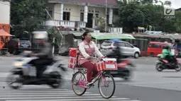 Pedagang minuman saat dengan hati-hati menyeberangi jalan di persimpangan Terminal Pulo Gadung, Jakarta, Rabu (5/9). Menurut warga, kecelakaan sering menimpa pengendara dan pejalan kaki. (Merdeka.com/Iqbal Nugroho)
