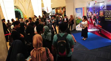 Seorang mahasiswi berfoto saat mengikuti Citizen Journalist Academy Energi Muda Pertamina, Jakarta, Kamis (27/7). Acara ini merupakan program pencarian bakat mahasiswa yang kreatif dalam bidang jurnalistik. (Liputan6.com/Helmi Afandi)
