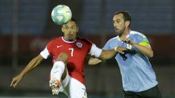 Bek Uruguay, Diego Godin, berebut bola dengan penyerang Chile, Alexis Sanchez, pada laga kualifikasi Piala Dunia 2020 zona Amerika Selatan di Estadio Centenario, Jumat (9/10/2020) pagi WIB. Uruguay menang 2-1 atas Chile. (AFP/Matilde Campodonico/pool)