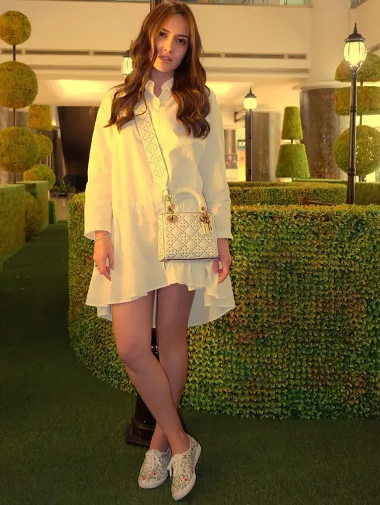 Seperti ini contohnya, Shandy tampil serba putih dengan mini dressnya, sling bag dan sneakersnya. Lagi-lagi, ia pun menggerai rambut panjangnya yang dibuat sedikit curly. (Instagram/shandyaulia)