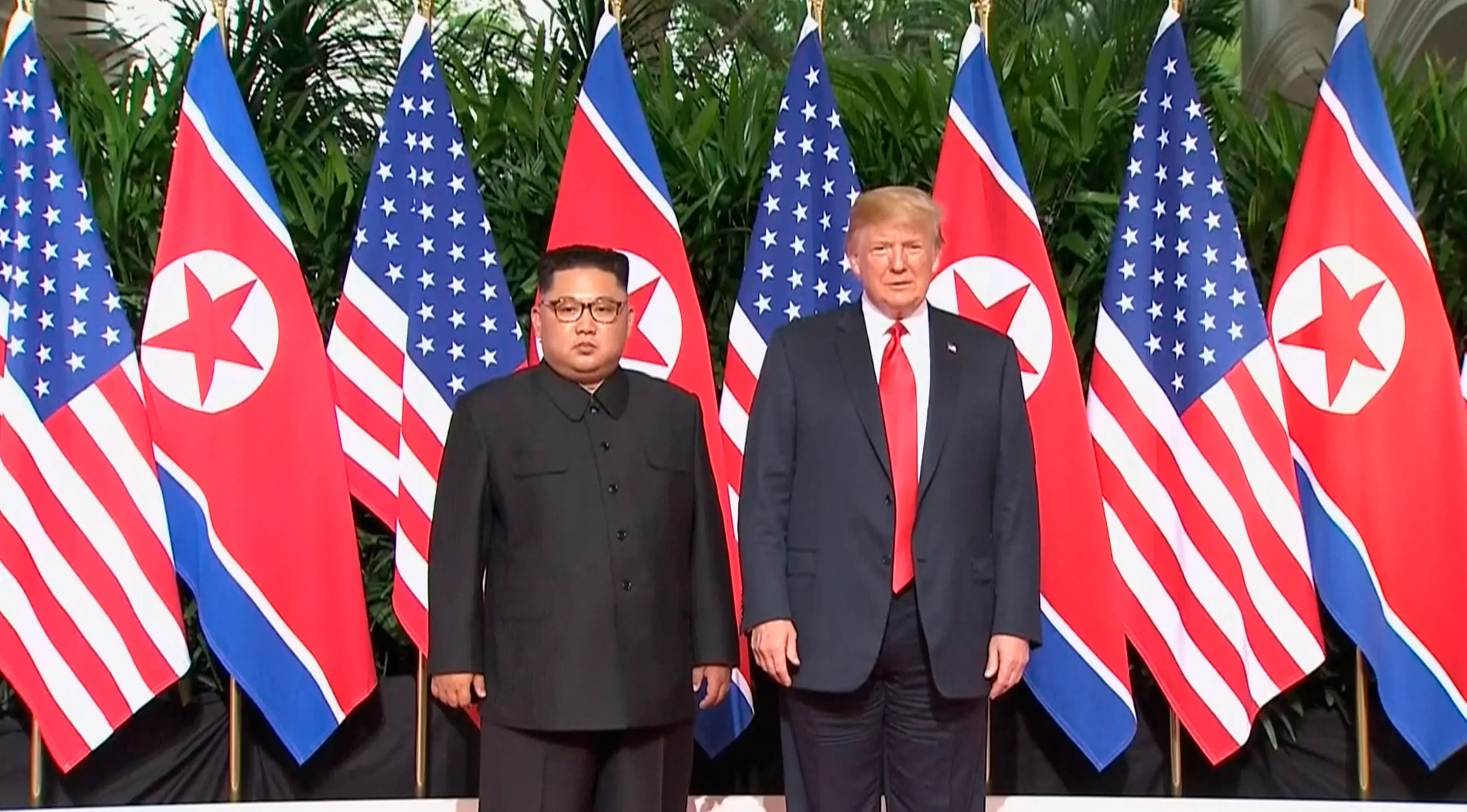 Presiden AS Donald Trump dan Pemimpin Korea Utara, Kim Jong-un berpose sebelum pertemuan mereka di resor Capella, Pulau Sentosa, Selasa (12/6). Pertemuan Trump  dan Kim sudah banyak dinantikan dunia. (Host Broadcaster Mediacorp Pte Ltd via AP)