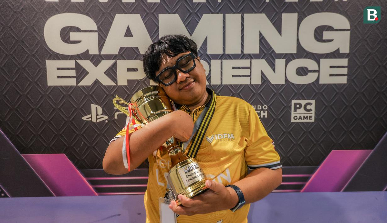 Atlet E-Sports Indonesia, Syamsul Arip berfoto bersama pialanya setelah memenangkan Lenovo Legion IDFM 2025 yang berlangsung di Sentinel Cyber Arena, Jakarta Timur, Minggu (23/02/2025). (Bola.com/Bagaskara Lazuardi)