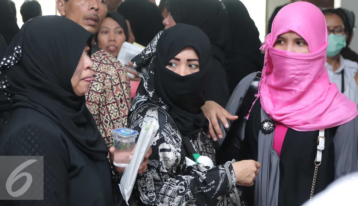 Sejumlah Tenaga Kerja Indonesia (TKI) menunggu bus di Bandara Soekarno Hatta,Tangerang, Rabu (11/11). Sebanyak 450 WNI overstayers dan TKI undocumented dari Jeddah, Arab Saudi dipulangkan pemerintah Indonesia. (Liputan6.com/Angga Yuniar)