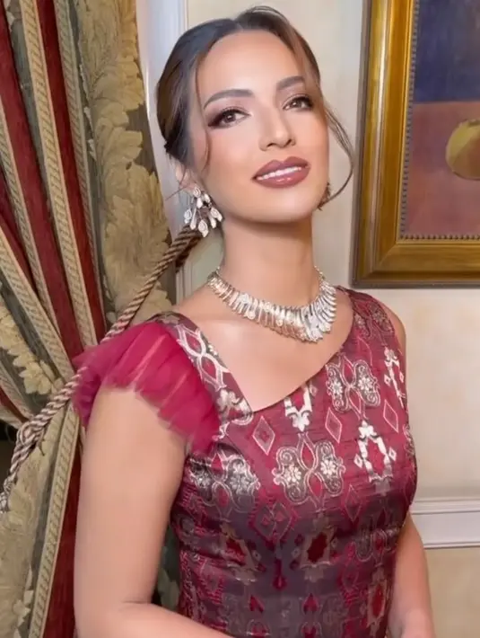 Detail gaun bernuansa merah itu dibuat tanpa lengan dengan bentuk asimetris pada bagian dadanya. [Instagram/ramadhaniabakrie]