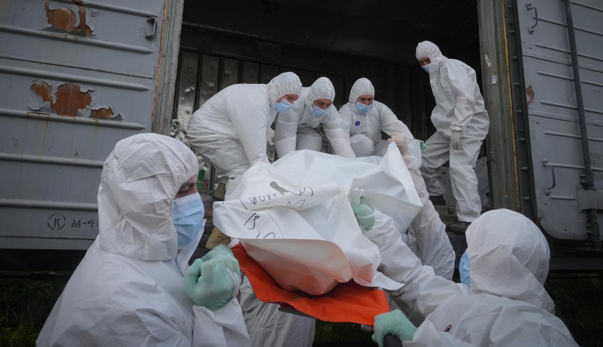 <p>Prajurit Ukraina mengumpulkan jenazah-jenazah tentara Rusia untuk ditaruh dalam gerbong kulkas kereta api di Kiev, Ukraina pada 13 Mei 2022. Jasad tentara Rusia tersebut dikumpulkan setelah pertempuran di wilayah Kiev dan Chernihiv. Kepala Kerja Sama Sipil-militer Ukraina, Volodymr Lyamzin, mengatakan negaranya bertindak sesuai dengan hukum internasional dan siap untuk mengembalikan jasad-jasad itu ke Rusia. (AP Photo/Efrem Lukatsky)</p>