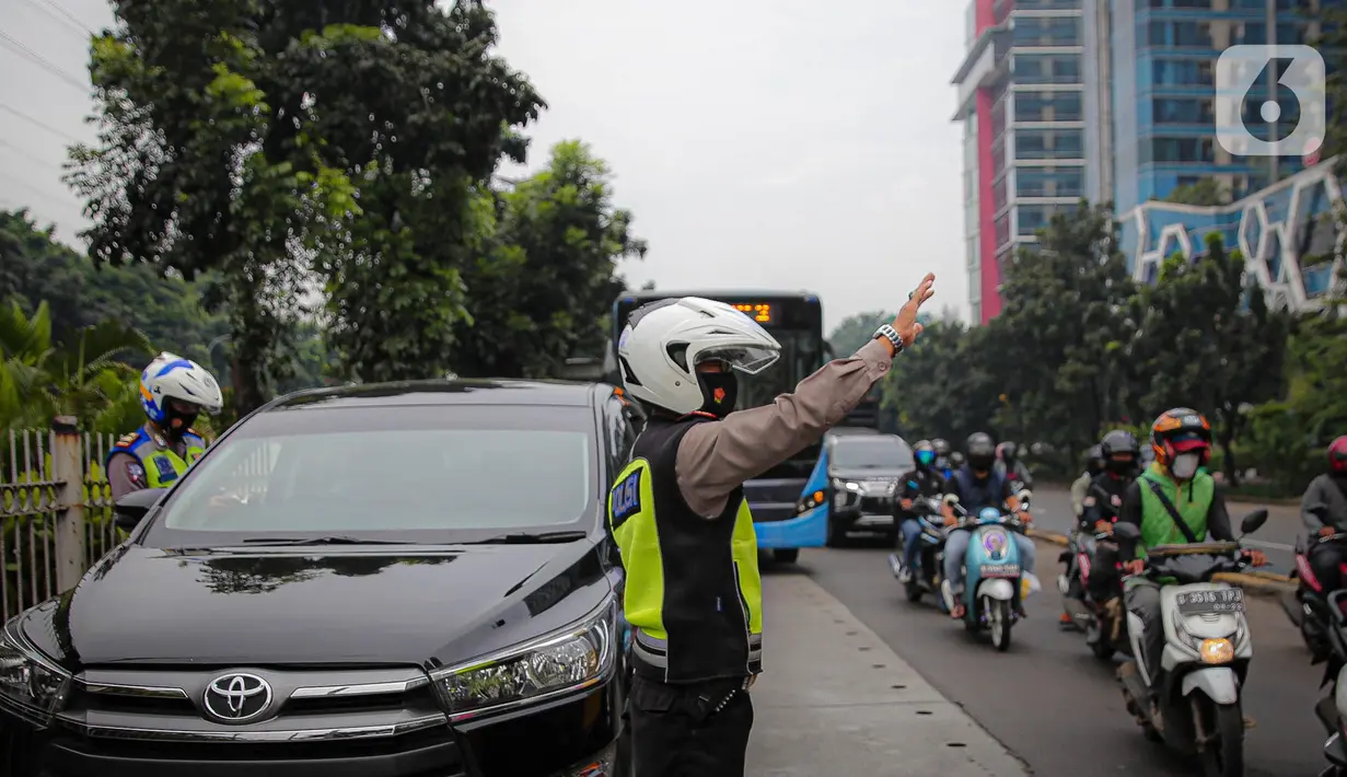 Anggota polisi melakukan penindakan kepada sebuah kendaraan saat ganjil genap di kawasan Jalan D.I Panjaitan, Jakarta, Senin (6/6/2022). Perluasan ganjil genap juga sesuai dengan Pergub DKI Jakarta Nomor 88 Tahun 2019. (Liputan6.com/Faizal Fanani)