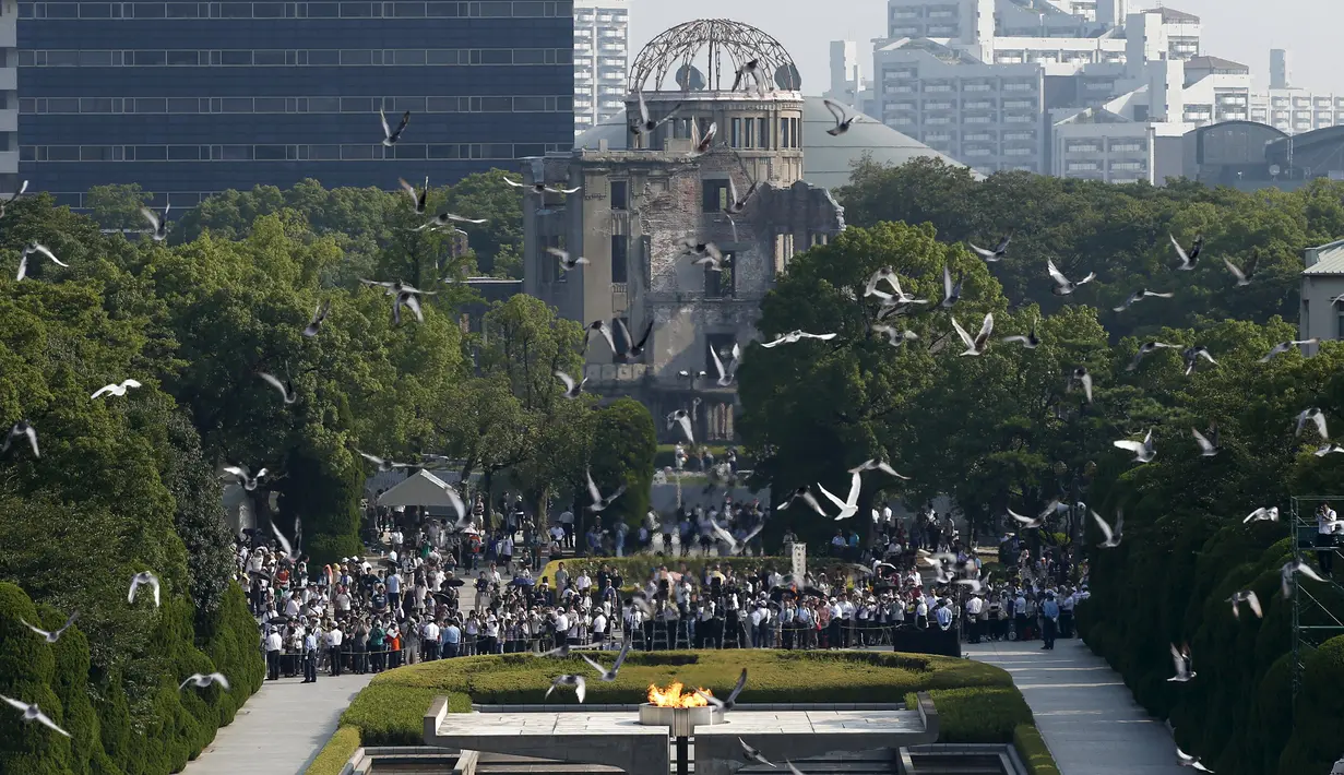 Burung Merpati terbang di atas Peace Memorial Park, dengan latar Monumen Bom Atom, pada saat upacara peringatan 70 tahun jatuhnya bom atom di Hiroshima, Jepang (6/8/2015). 140.000 penduduk Jepang tewas akibat Bom Atom. (REUTERS/Toru Hanai)