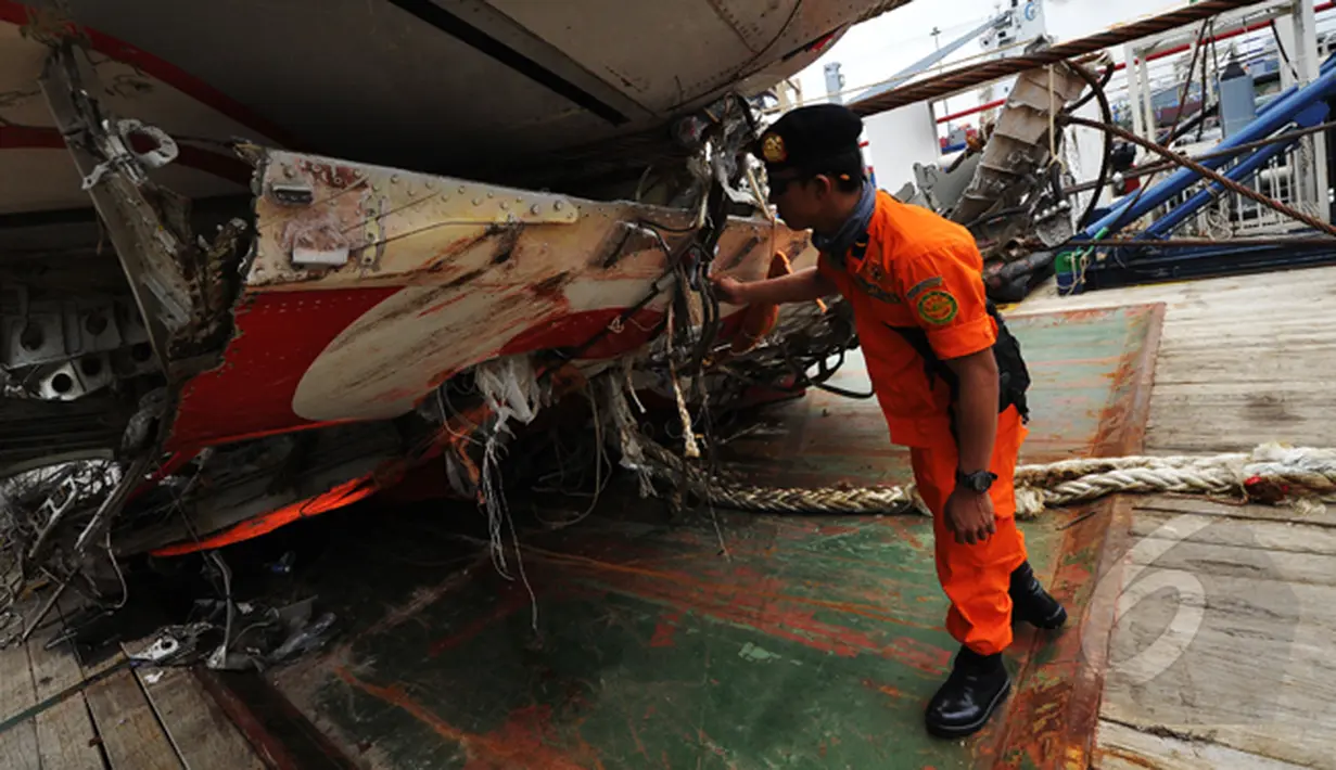 Petugas dari Basarnas memeriksa bangkai badan pesawat Airasia QZ8501 di Pelabuhan Tanjung Priok, Jakarta, Senin (2/3/2015). (Liputan6.com/Faizal Fanani)