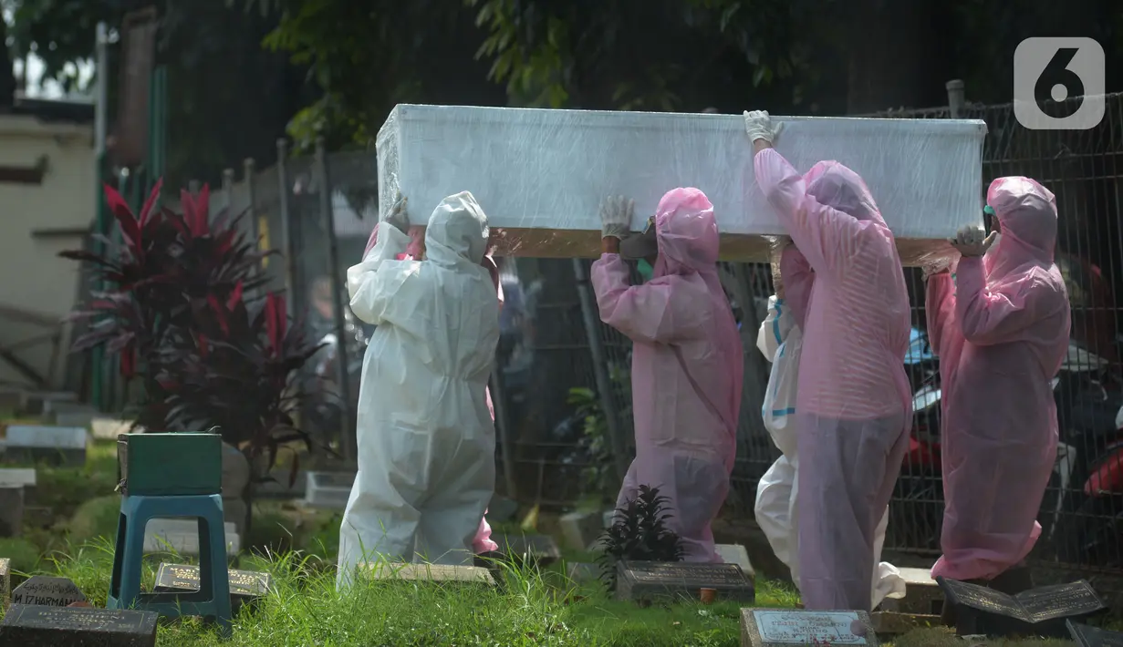 Petugas pemulasaraan jenazah Covid-19 membawa peti jenazah yang meninggal ketika menjalani isolasi mandiri untuk dimakamkan di Kampung Gedong, Jakarta, Sabtu (10/7/2021). Proses pemulasaran jenazah dilakukan sesuai prokes Covid-19 dikarenakan hasil test swab korban positif. (merdeka.com/Imam Buhori)