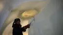 Pemahat memberikan sentuhan akhir di dalam patung es di festival Ice and Snow World Harbin, di Harbin, timur laut China, Jumat (3/1/2019). Menjadi acara tahunan, festival es terbesar dunia ini menghadirkan beragam patung dengan bentuk yang besar dan mewah bagi para pengunjungnya. (NOEL CELIS/AFP)