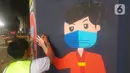 Mahasiswa melukis mural bertemakan sosialisasi pencegahan Covid-19 di kolong jalan tol dalam kota, Kebun Nanas, Jakarta, Jumat (4/12/2020). Kegiatan sekitar 90 tiang kolong tol sepanjang jalan MT Haryono ini difasilitasi Satgas Covid-19. (merdeka.com/Arie Basuki)