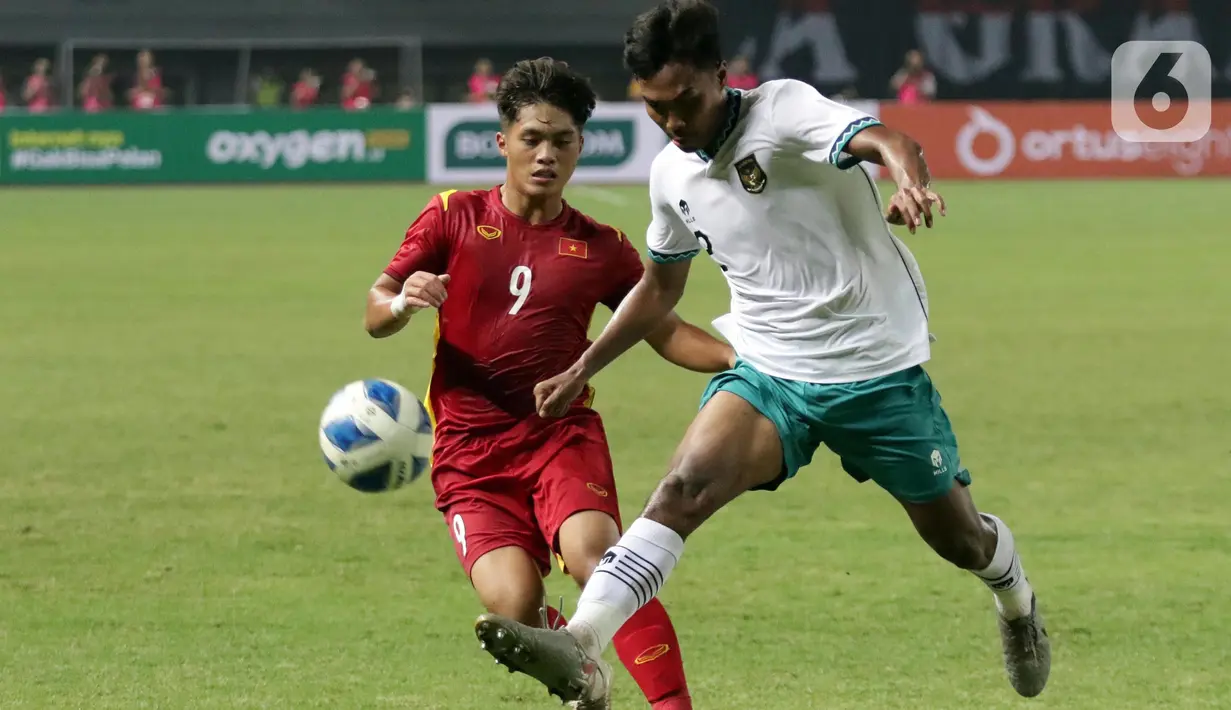 Bek Timnas Indonesia U-19, Ahmad Rusadi berusaha menahan laju Nguyen Quoc Viet (Vietnam U-19) pada kualifikasi grup A Piala AFF U-19 2022 di Stadion Patriot Candrabhaga, Bekasi, Jawa Barat, Sabtu (2/7/2022). Laga kedua tim berlangsung ketat, saling adu serangan dan berusaha menampilkan permainan terbaik. (Liputan6.com/Helmi Fithriansyah)