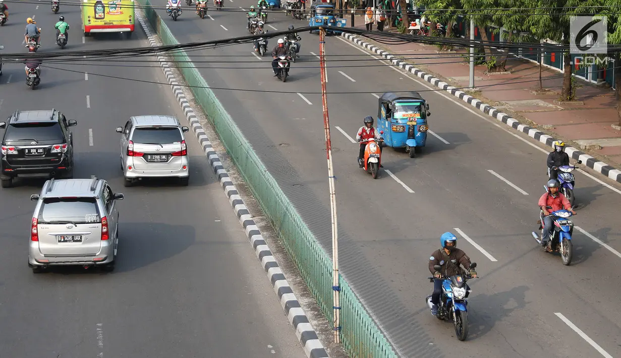 Sejumlah pengendara melintas dibawah kabel yang ditopang tiang bambu di kawasan Pasar Baru, Jakarta, Selasa (12/9). Selain membahayakan pengguna jalan, buruknya instalasi kabel tersebut juga merusak estetika kota. (Liputan6.com/Immanuel Antonius)