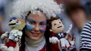 Suporter cantik dengan wajah bendera Argentina dan Islandia memegang maskot Piala Dunia 2018 di Spartak Stadium, Moskow, (16/6/ 2018). Argentina dan Islandia bermain imbang 1-1. (AP/Ricardo Mazalan)