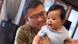 Baby Ameena sendiri terlihat begitu menikmati momen kebersamaan dengan sang kakek. Begini tawa manisnya yang terus menghiasi wajah cantiknya saat digendong Anang Hermansyah.(instagram.com/ananghijau)