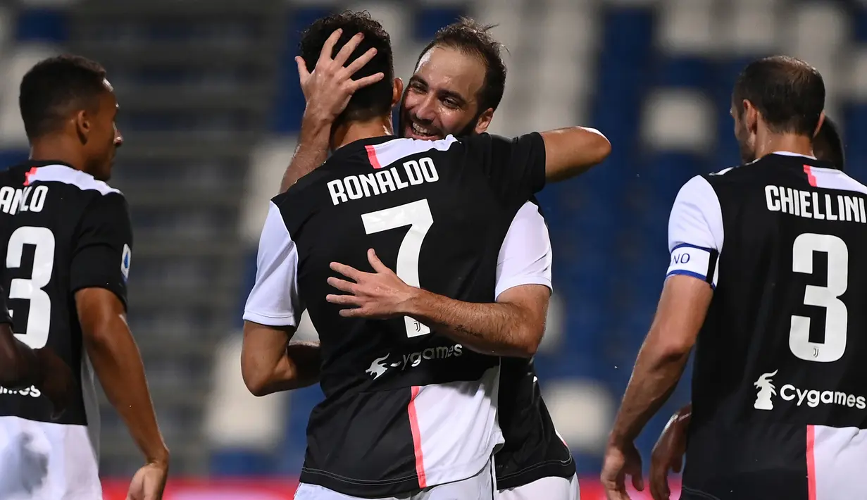 Penyerang Juventus, Gonzalo Higuain memeluk rekannya Cristiano Ronaldo usai mencetak gol ke gawanag Sassuolo pada pertandingan lanjutan Liga Serie A Italia di stadion Mapei di Reggio Emilia (15/7/2020). Juventus bermain imbang 3-3 atas Sassuolo. (AFP/Marco Bertorello)
