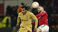 Bek Manchester United, Luke Shaw menyundul bola melewati pemain Barcelona Jules Kounde selama pertandingan leg kedua playoff Liga Europa stadion Old Trafford di Manchester, Inggris, Jumat (24/2/2023). Manchester selanjutnya akan bertemu dengan juara babak grup Liga Europa untuk berebut tiket perempat final. (AP Photo/Dave Thompson)