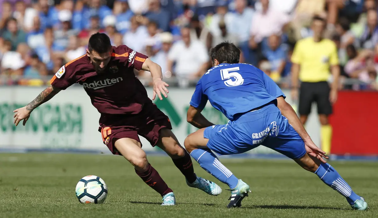 Striker Barcelona, Lionel Messi, berusaha melewati gelandang Getafe, Markel Bergara pada laga La Liga di Stadion Alfonso Perez, Sabtu (16/9/2017). Barcelona menang 2-1 atas Getafe. (AP/Francisco Seco)