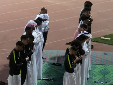 Para pemain Timas Qatar salat berjamaah sebelum sesi latihan mereka di Abu Dhabi (31/1). Timnas Qatar akan bertanding melawan wakil dari Asia Timur, Jepang pada final Piala Asia 2019. (AFP Photo/Roslan Rahman)