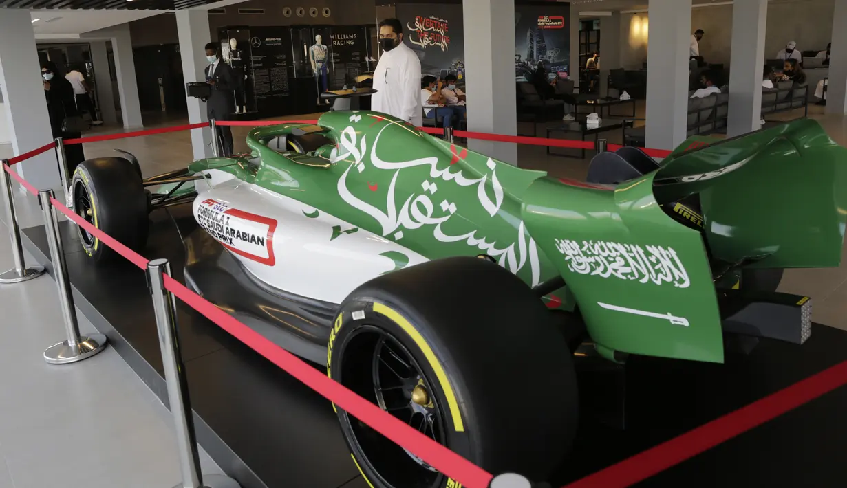 Seorang pria melihat mobil balap di pusat tiket gelaran Formula One (F1), di Jeddah, Arab Saudi, Selasa (30/11/2021). Arab Saudi untuk pertama kalinya dipercaya menjadi tuan rumah balapan F1 2021, yang akan berlangsung 3-5 Desember mendatang. (AP Photo/Amr Nabil)