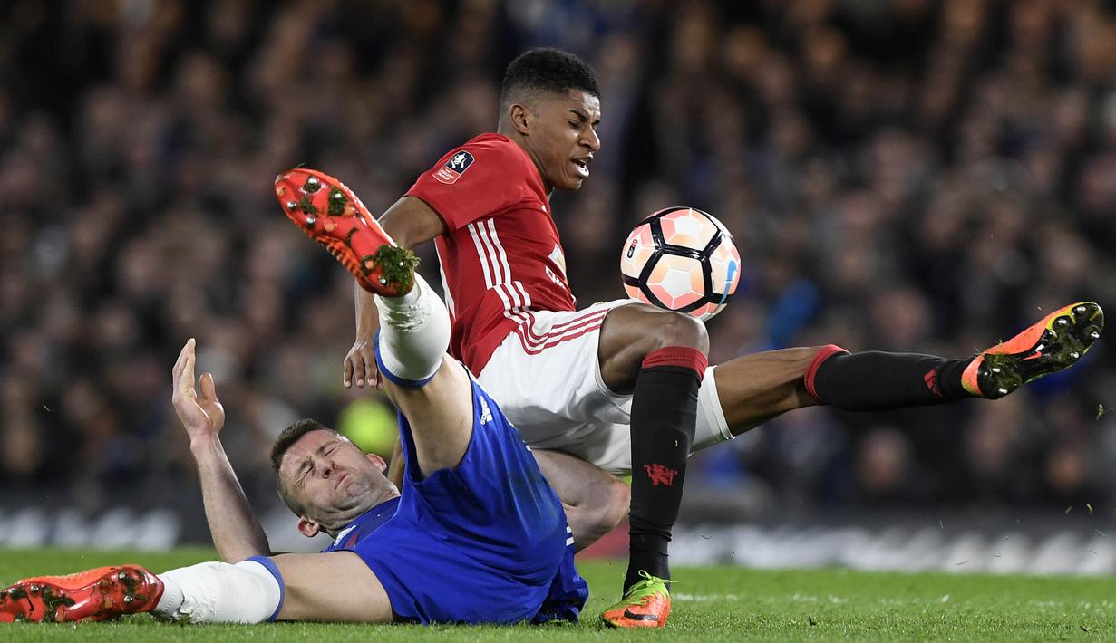 Striker Manchester United, Marcus Rashford, berebut bola dengan bek Chelsea, Gary Cahill. Pada laga ini pemain Setan Merah melakukan 14 kali pelanggaran, sementara Chelsea hanya tujuh kali. (EPA/Will Oliver)