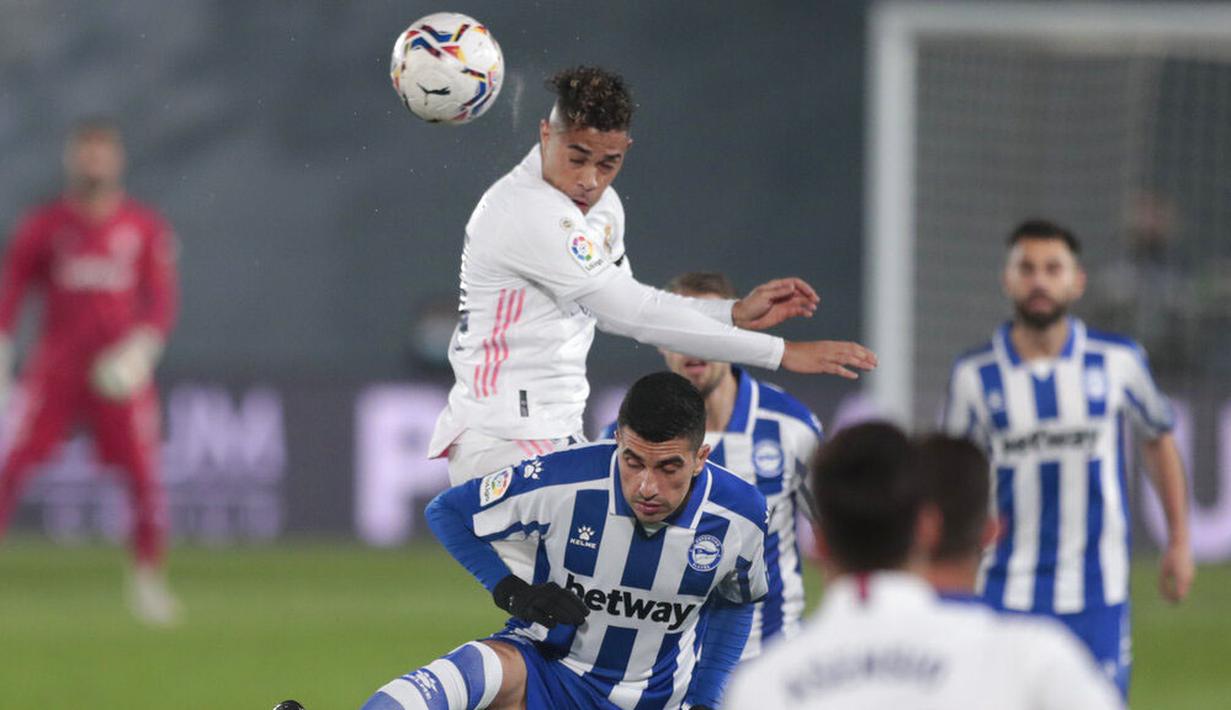 Pemain Real Madrid, Mariano Diaz, duel udara dengan pemain Alaves, Rodrigo Battaglia, pada laga Liga Spanyol di Stadion Alfredo di Stefano, Sabtu (28/11/2020). Real Madrid takluk dengan skor 1-2. (AP/Bernat Armangue)