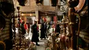 <p>Warga lalu lalang melintasi toko barang antik di Baghdad, Irak, Rabu (20/3). (AP Photo/Hadi Mizan)</p>