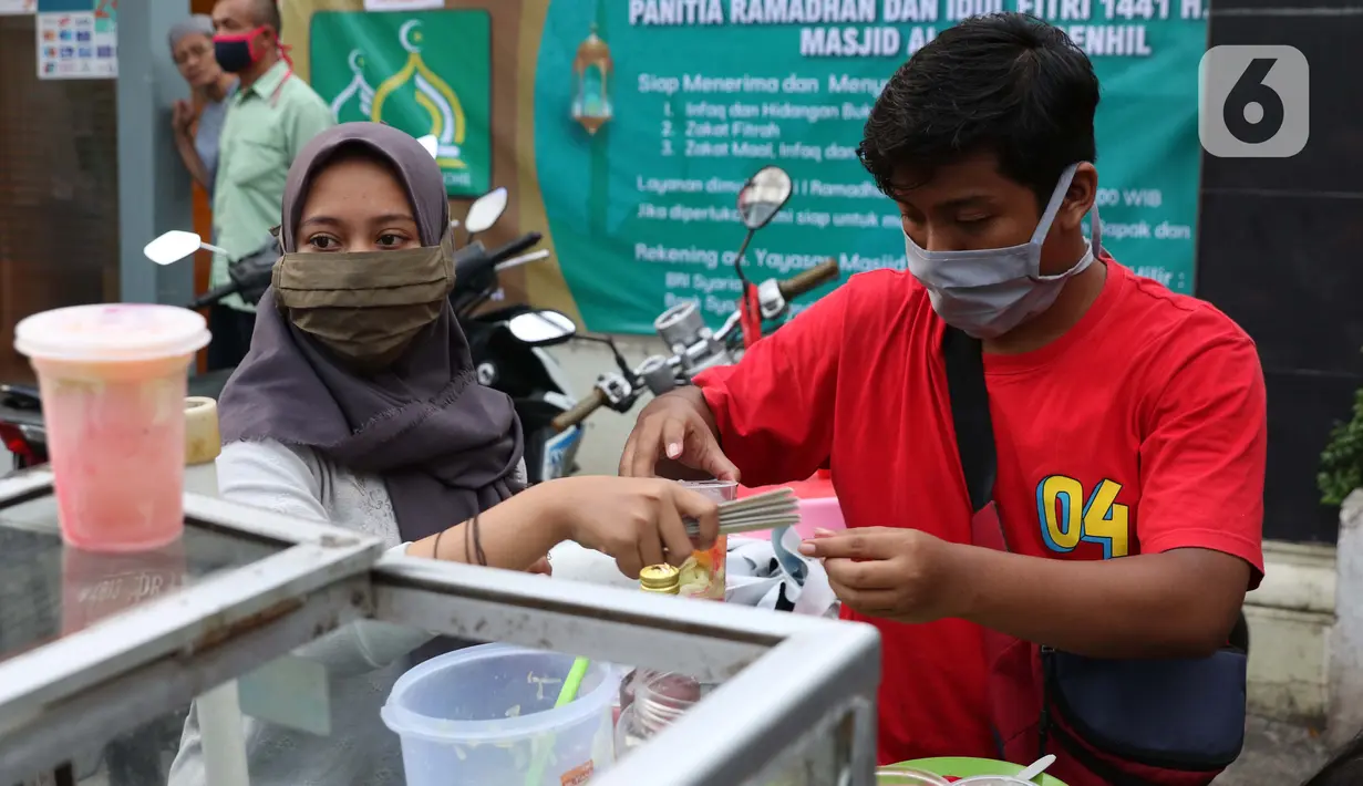 Pedagang menyiapkan minuman untuk berbuka puasa di kawasan Bendungan Hilir, Jakarta, Sabtu (25/4/2020). Meski ditengah pandemi virus Covid-19, masyarakat masih antusias berburu penganan berbuka puasa dengan tetap menerapkan pola jaga jarak dan memakai masker. (Liputan6.com/Helmi Fithriansyah)