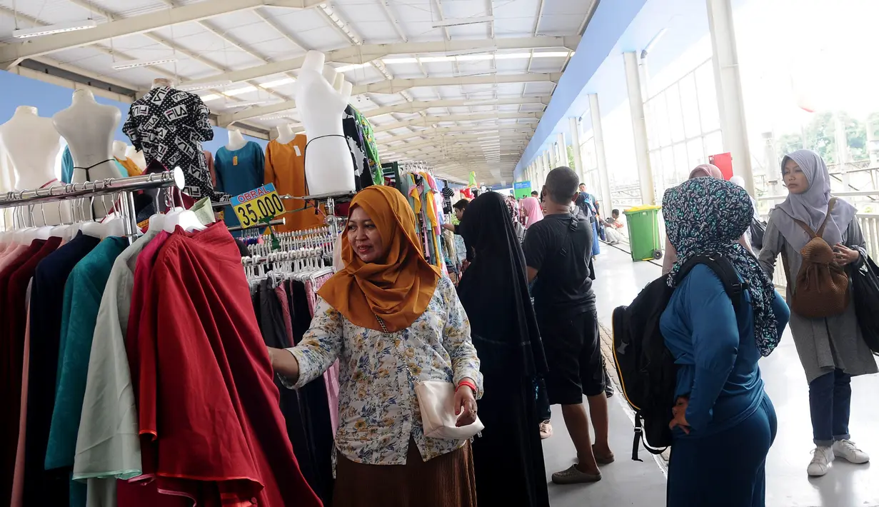 Calon pembeli memilih pakaian yang dijual di jembatan penyeberangan multiguna (JPM) atau Skybridge Tanah Abang, Jakarta, Kamis (7/2). Pejalan kaki yang menuju dan dari Stasiun Tanah Abang harus mengakses skybridge. (Liputan6.com/Herman Zakharia)