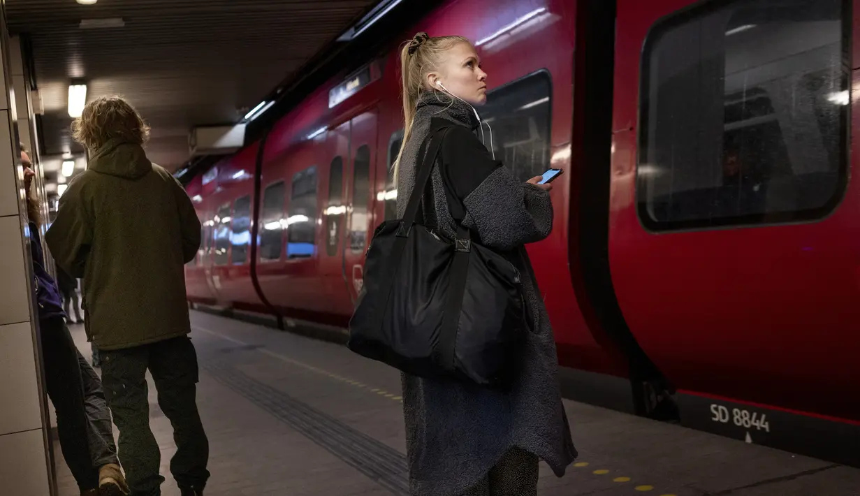 Penumpang berdiri di Stasiun Metro Noerreport di Kopenhagen, Selasa (1/2/2022). Ini adalah kedua kalinya Denmark mencoba kembali ke kehidupan normal setelah pada 10 September 2021 membatalkan semua pembatasannya, sebelum menerapkan kembali pada awal November. (Liselotte Sabroe/Ritzau Scanpix via AP)