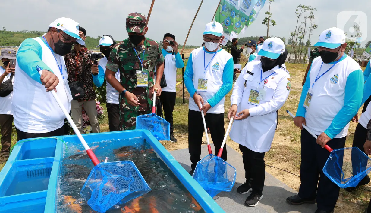 Wakil Menteri PUPR John Wempi Wetipo (kiri) menangkap ikan yang akan dilepas ke Bendungan Randugunting pada peringatan Hari Air Dunia (HAD) ke-30 Blora, Jawa Tengah (30/03/2022). Tema “MANTAB : diadopsi dari tema international “Groundwater: Making the Invisible Visible.” (Liputan6.com/HO/Arief PUPR)