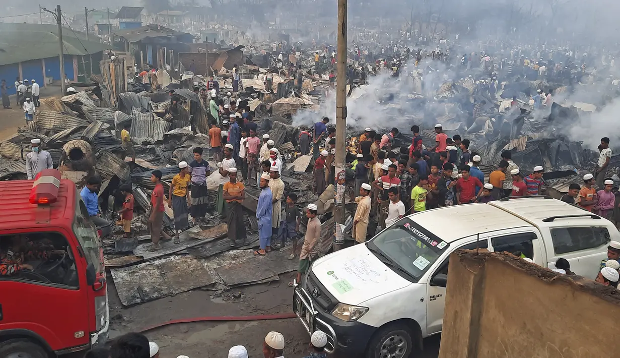 Pengungsi Rohingya berkumpul setelah kebakaran besar di kamp pengungsi di Balukhali, Bangladesh selatan (22/3/2021). Kebakaran bermula di salah satu dari 34 kamp pada tengah malam. (AFP Photo)