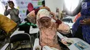 Seorang pengemudi ojek online wanita memasang jilbab jelang peragaan busana di Rawamangun, Jakarta, Jumat (20/4). Kegiatan tahunan ini sebagai bentuk apresiasi GO-Mart DanDan kepada mitra driver. (Liputan6.com/Fery Pradolo)