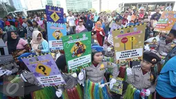 Puluhan polisi cilik membawa poster himbauan patuhi lalu lintas saat melakukan kampanye keselamatan berkendara di kawasan Bundaran HI, Jakarta, Minggu (12/3). (Liputan6.com/Immanuel Antonius)