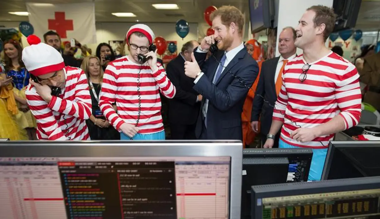 Pangeran Harry mengacungkan jempolnya sambil mengangkat telepon saat menjadi broker acara amal tahunan ICAP di London, Rabu (7/12). Pangeran Harry menjadi broker dadakan guna mengumpulkan dana amal dari 60 kantor di seluruh dunia (REUTERS/Geoff Pugh/Pool)