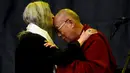 Musisi, Patti Smith mencium kepala Dalai Lama saat acara Glastonbury Festival, Inggirs, (28/6/2015). Dalai Lama akan berulang tahun yang ke-80 pada 6 Juli 2015 nanti. Namun ia merayakannya lebih awal di Glastonbury Festival. (REUTERS/Dylan Martinez)