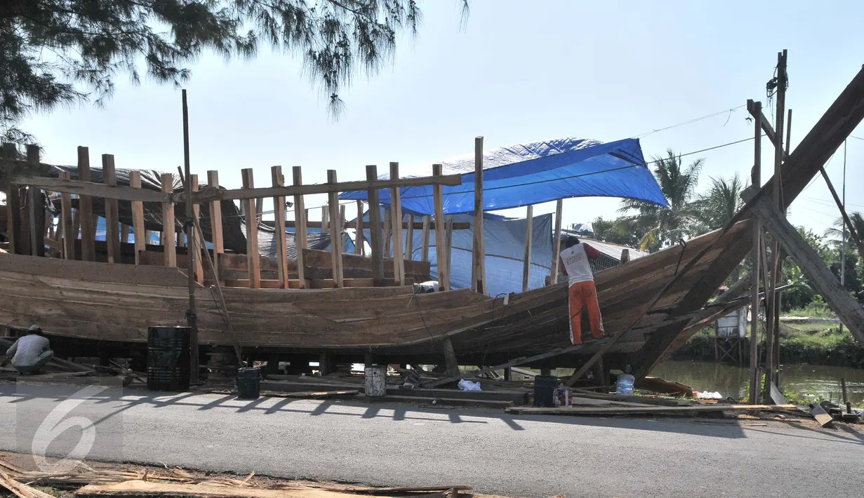 Pekerja membuat kapal nelayan di Karangsong, Indramayu, Jawa Barat, Rabu (17/6). Sulit dan mahalnya memperoleh kayu merupakan kendala utama pembuatan kapal berkapasitas sekitar 30 grosstone tersebut. (Liputan6.com/Herman Zakharia)