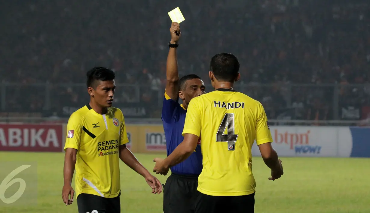 Wasit Prasetyo Hadi memberi kartu kuning buat bek Semen Padang, Handi Ramdhan saat laga Torabika Soccer Championship presented by IM3 Ooredoo kontra Persija di Stadion GBK, Jakarta, Minggu (8/5/2016). Persija unggul 1-0. (Liputan6.com/Helmi Fithriansyah)