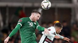 Bek timnas Irlandia, Matt Doherty menyundul bola di atas penyerang Portugal Andre Silva pada laga Grup A Kualifikasi Piala Dunia 2022 Zona Eropa di Stadion Aviva, Jumat (12/11/2021) dinihari WIB. Diwarnai kartu merah Pepe, Portugal ditahan imbang 0-0 oleh Irlandia. (AP Photo/Peter Morrison)