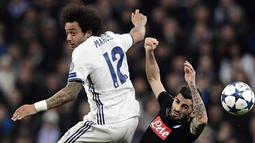 Bek Napoli, Albania Elseid Hysaj (kanan) berusaha menjangkau bola dari kejaran pemain Real Madrid, Marcelo pada laga 16 besar Liga Champions di Santiago Bernabeu stadium, Madrid (15/2/2017). Madrid menang 3-1.  (AFP/Javier Soriano)