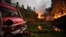 Petugas damkar beristirahat saat kebakaran hutan di Penela, Portugal Tengah, Minggu (18/6). Kebakaran hutan di Portugal terjadi di tengah gelombang panas yang kian sering terjadi dan angin kencang yang menyebarkan api. (PATRICIA DE MELO MOREIRA/AFP)