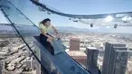 Seorang wanita mencoba berseluncur menggunakan skyslide di lantai 69 dan 70 dari Bank Tower AS, Los Angeles , California, (20/6). Tempat yang dinamakan OUE Skyspace LA ini kita dapat melihat panorama indah kota LA dari atas. (REUTERS / Lucy Nicholson)