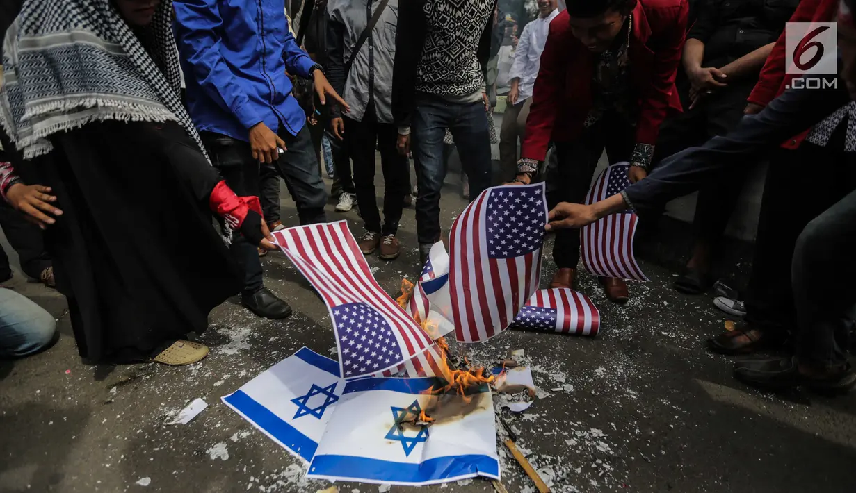 Puluhan massa membakar bendera Amerika Serikat dan Israel dalam Aksi Bela Palestina di depan Kedubes AS, Jakarta, Jumat (15/12). Mereka memprotes sikap Presiden Donald Trump yang mengakui Yerusalem sebagai Ibu Kota Israel. (Liputan6.com/Faizal Fanani)