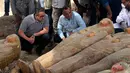 Menteri Purbakala Mesir Khaled el-Anany melihat penemuan 20 peti mati kuno terbuat dari kayu di kota Luxor, 15 Oktober 2019. Pejabat Mesir belum menjelaskan asal zaman peti-peti itu namun, lokasi penemuan berada di bekas wilayah kota kuno Thebes berdiri. (Egyptian Ministry of Antiquities via AP)