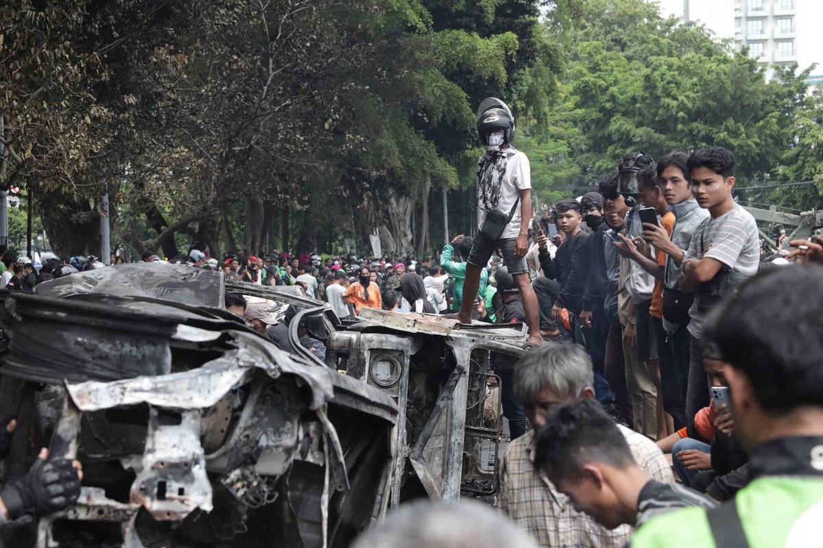 FOTO: Warga Ambil Bangkai Mobil Usai 10 Kendaraan Dibakar di Depan Mako Brimob Kwitang