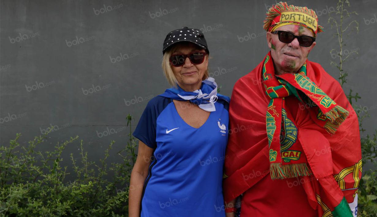 Sepasang suami istri pendukung Portugal dan Prancis foto bersama sebelum menyaksikan laga final Piala Eropa (Bola.com/Vitalis Yogi Trisna)