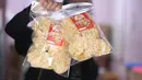Pekerja menunjukkan salah satu hasil produksi pembuatan keripik tempe di rumah usaha Keripik Tempe Mama Tina, Kebayoran Baru, Jakarta Selatan, Kamis (7/5/2026). Keripik Tempe Mama Tina merupakan usaha rumahan memproduksi keripik tempe dengan beragam varian rasa seperti original bawang putih, balado, barbeque, hingga sapi panggang. (merdeka.com/Arie Basuki)