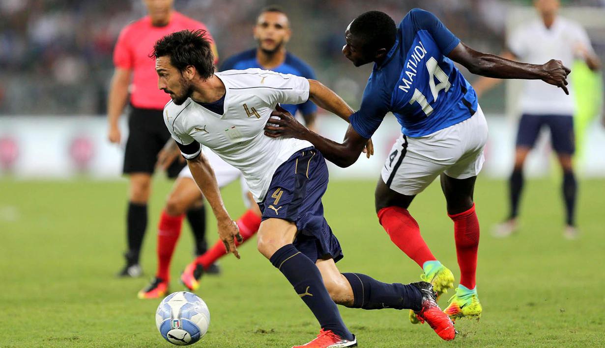 Bek Italia, Davide Astori, berusaha melewati gelandang Prancis, Blaise Matuidi. Pada laga ini Italia menggunakan formasi 3-5-2, sementara Prancis menggunakan skema 4-3-3. (EPA/Tony Vece)
