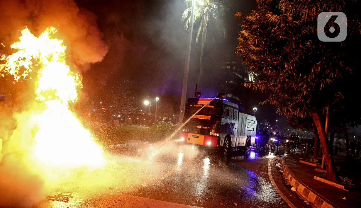 Mobil polisi menyemprotkan air untuk memadamkan api usai demonstrasi yang berujung anarkis di kawasan Bundaran HI, Jakarta, Kamis (8/10/2020). Massa membakar sejumlah barang saat demonstrasi menolak pengesahan UU Cipta Kerja. (Liputan6.com/Faizal Fanani)