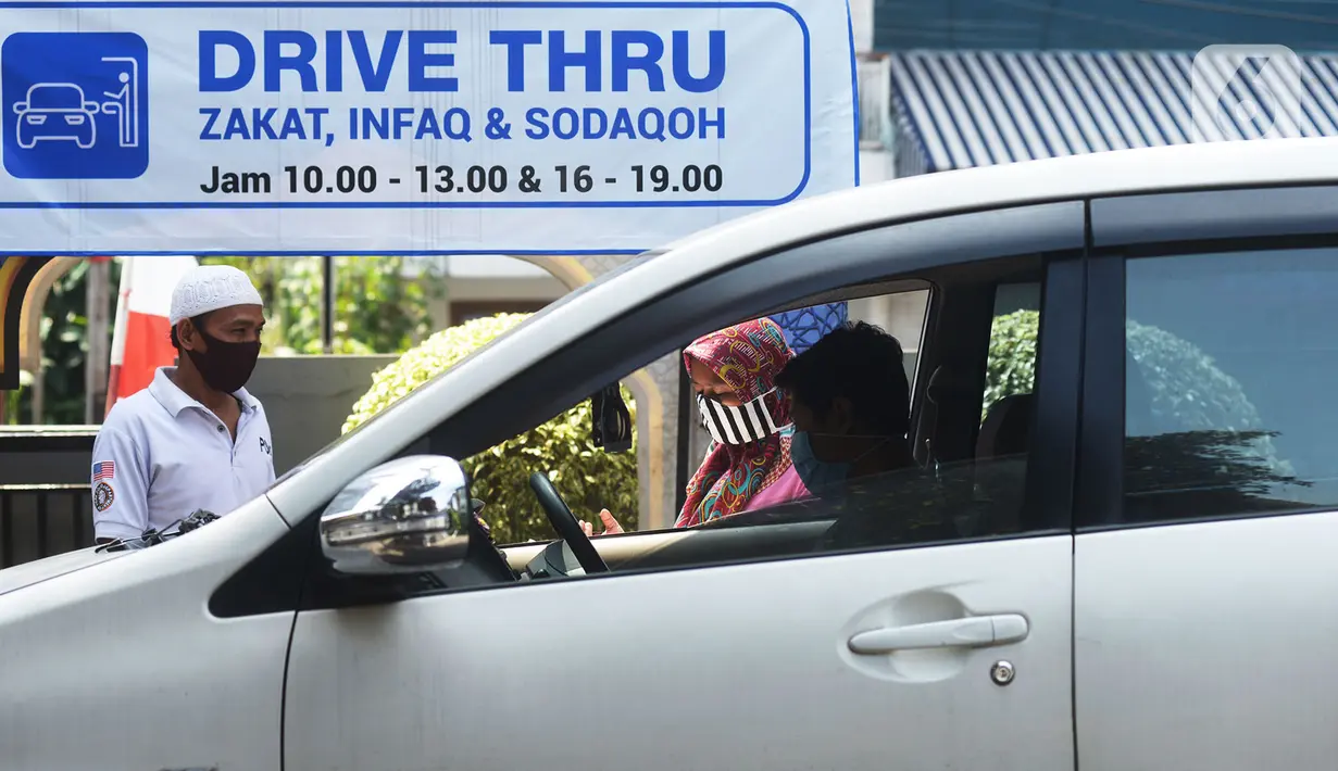 Panitia zakat fitra melakukan pengisian data di Masjid Nurul Hidaya, Jakarta, Sabtu (16/5/2020). Pembayaran zakat drive thru ini guna mempermudah warga dan jemaah yang ingin menyalurkan zakat, infaq dan shodakoh tanpa harus turun mobil serta memutus penyebaran Covid-19. (merdeka.com/Imam Buhori)